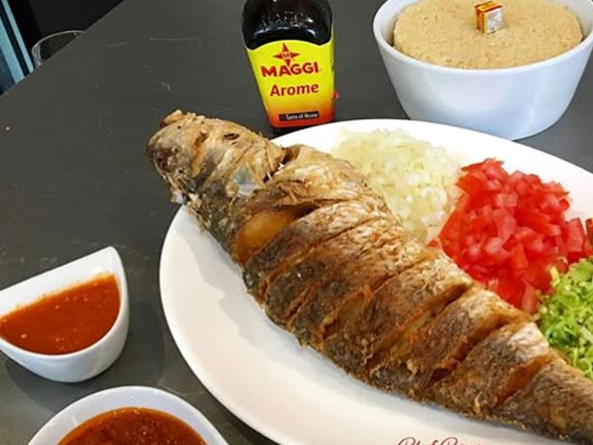 Poisson entier servi en grand plat avec riz et sauces